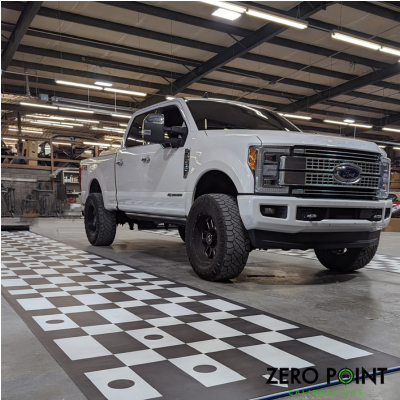 A white FORD truck having ADAS calibrations completed in the Zero Point Calibrations workshop.